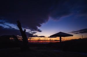 瞑色がきれいな夕暮れの中に東屋が影のように映りこでる写真