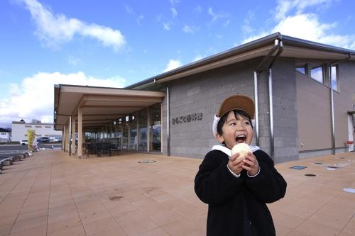 青い空の下、キャップを被った男の子が大きな口を開けて、おいしそうに肉まんにかぶりつきそうな様子の準グランプリの写真