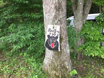 熊のイラストとあいさつトントンと書かれた看板が木に取り付けられている写真