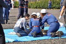 女性団員がブルーシートの上で救助の訓練をしている様子の写真